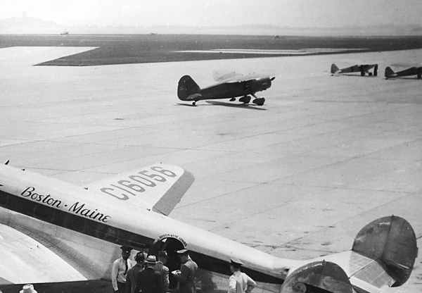 The famous Stinson gullwing design is shown in a Stinson Reliant on the tarmac at Boston Airport.