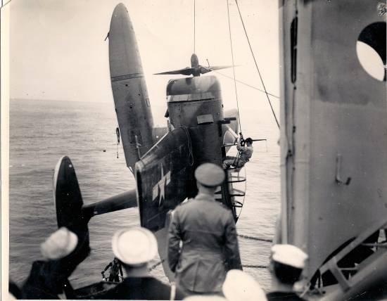 The floats did not lie. This is indeed an OS-2U Kingfisher being hoisted back aboard the U.S. Navy cruiser, USS Pasadena CL-65.